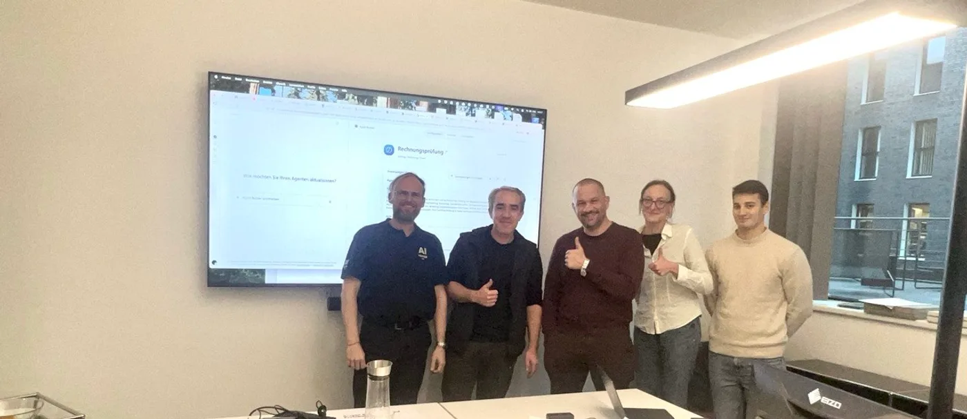 Team eines Frankfurter Architekturbüros mit André Heiner, Daumen hoch vor dem gemeinsam gebauten Copilot-Agenten für die Rechnungsprüfung